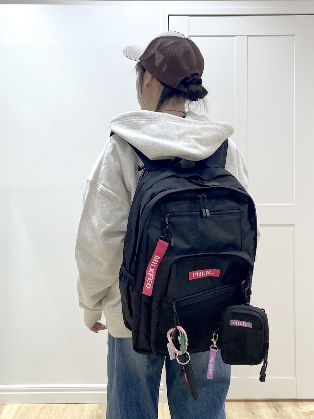 ベージュ系のパーカー、ブルー系のデニムパンツ、ブラック系のカーディガン/ボレロを着用したレディースの冬コーディネートの6枚目の写真