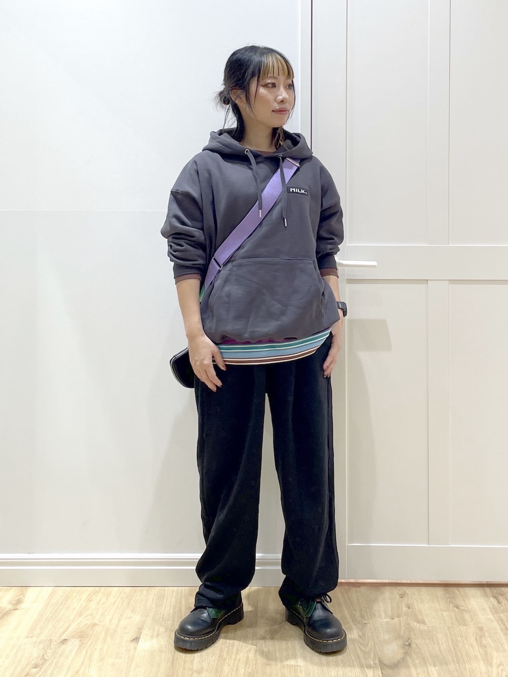 パープル系のショルダーバッグ、グレー系のパーカー、パープル系のTシャツ/カットソーを着用したレディースの秋コーディネートの3枚目の写真