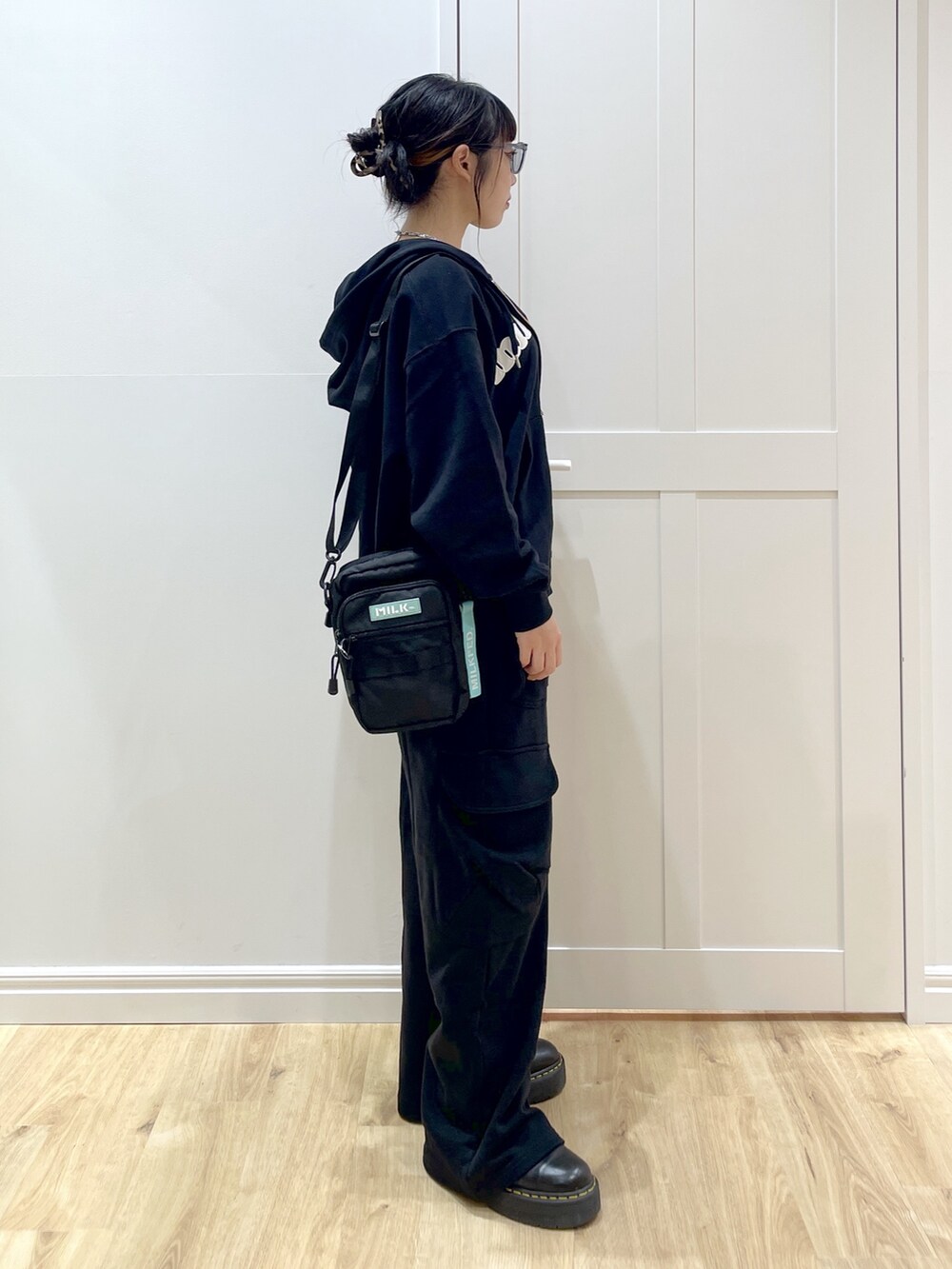 ブラック系のブーツ、ブラック系のスウェットパンツ、ブラック系のパーカーを着用したレディースの夏コーディネートの5枚目の写真