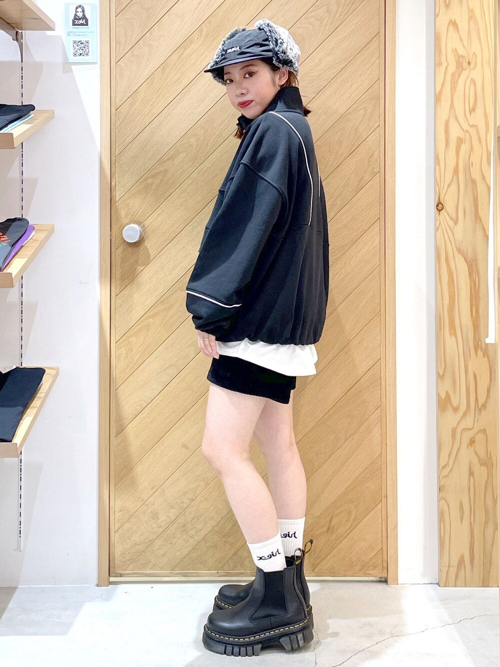 ブラック系のスウェット、ホワイト系のTシャツ/カットソー、ブラック系のブーツを着用したレディースの秋コーディネートの3枚目の写真