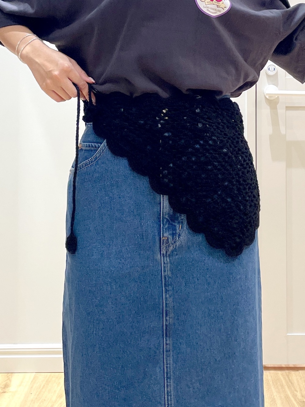 ブラック系のショルダーバッグ、グレー系のTシャツ/カットソー、ブルー系のデニムスカートを着用したレディースの夏コーディネートの6枚目の写真