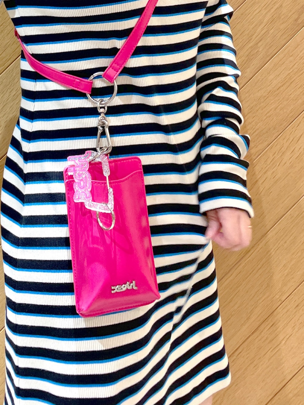 ブラック系のブーツ、ブラック系のワンピース、ピンク系のスマホグッズを着用したレディースの春コーディネートの2枚目の写真