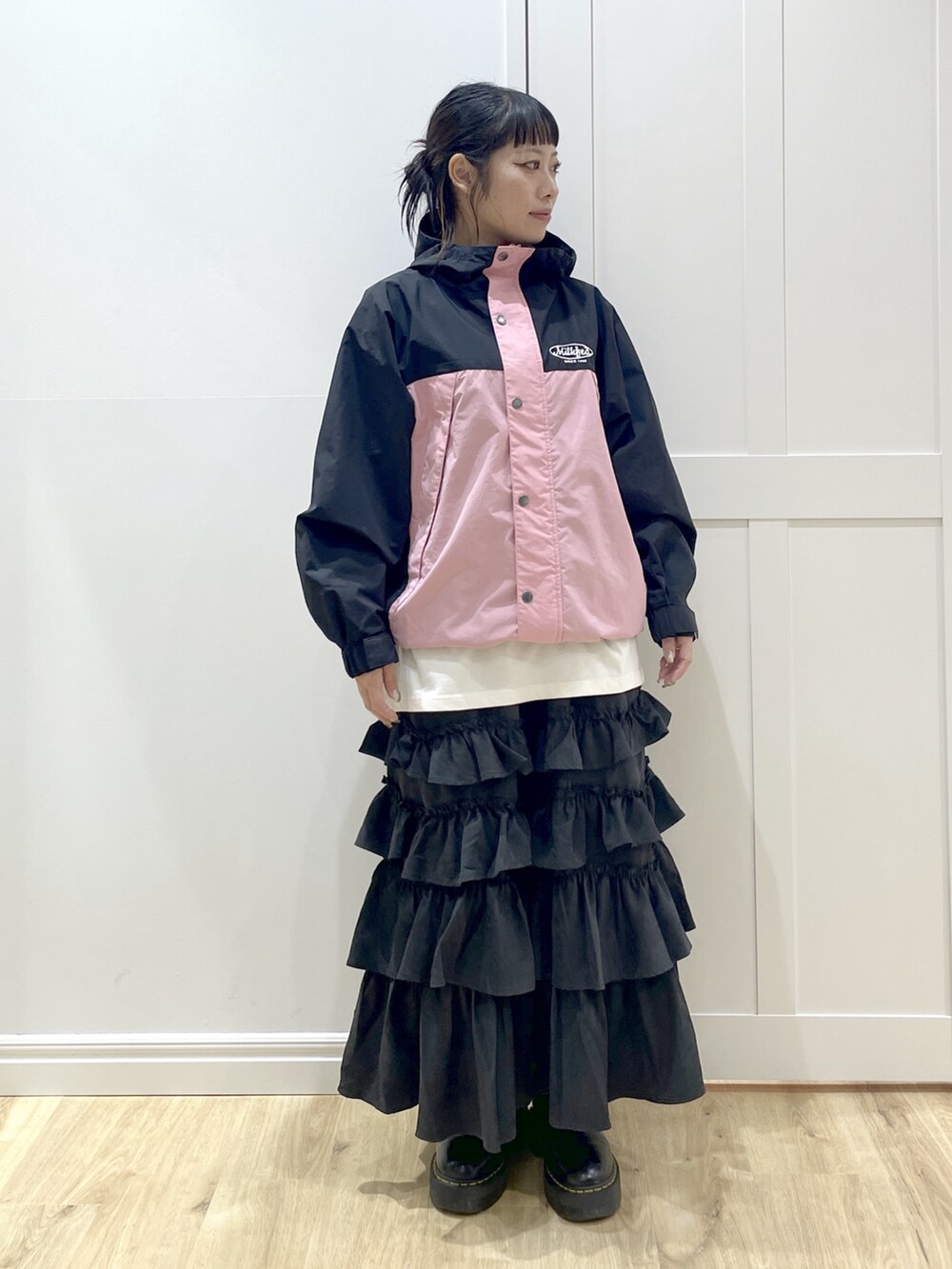 ブラック系のスカート、ホワイト系のTシャツ/カットソー、ピンク系のマウンテンパーカーを着用したレディースの秋コーディネートの4枚目の写真