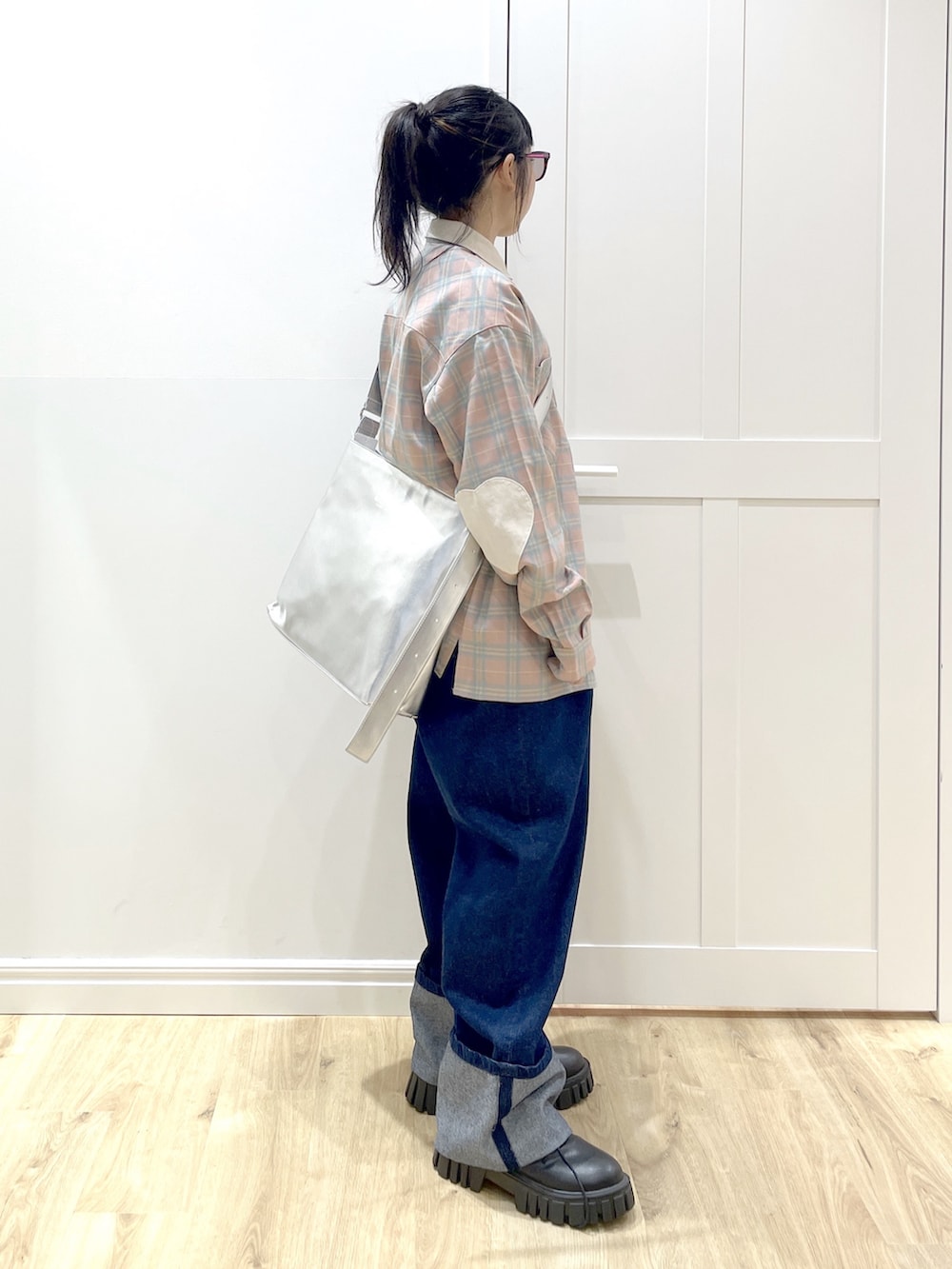 ブルー系のデニムパンツ、ピンク系のシャツ/ブラウス、シルバー系のショルダーバッグを着用したレディースの秋コーディネートの3枚目の写真