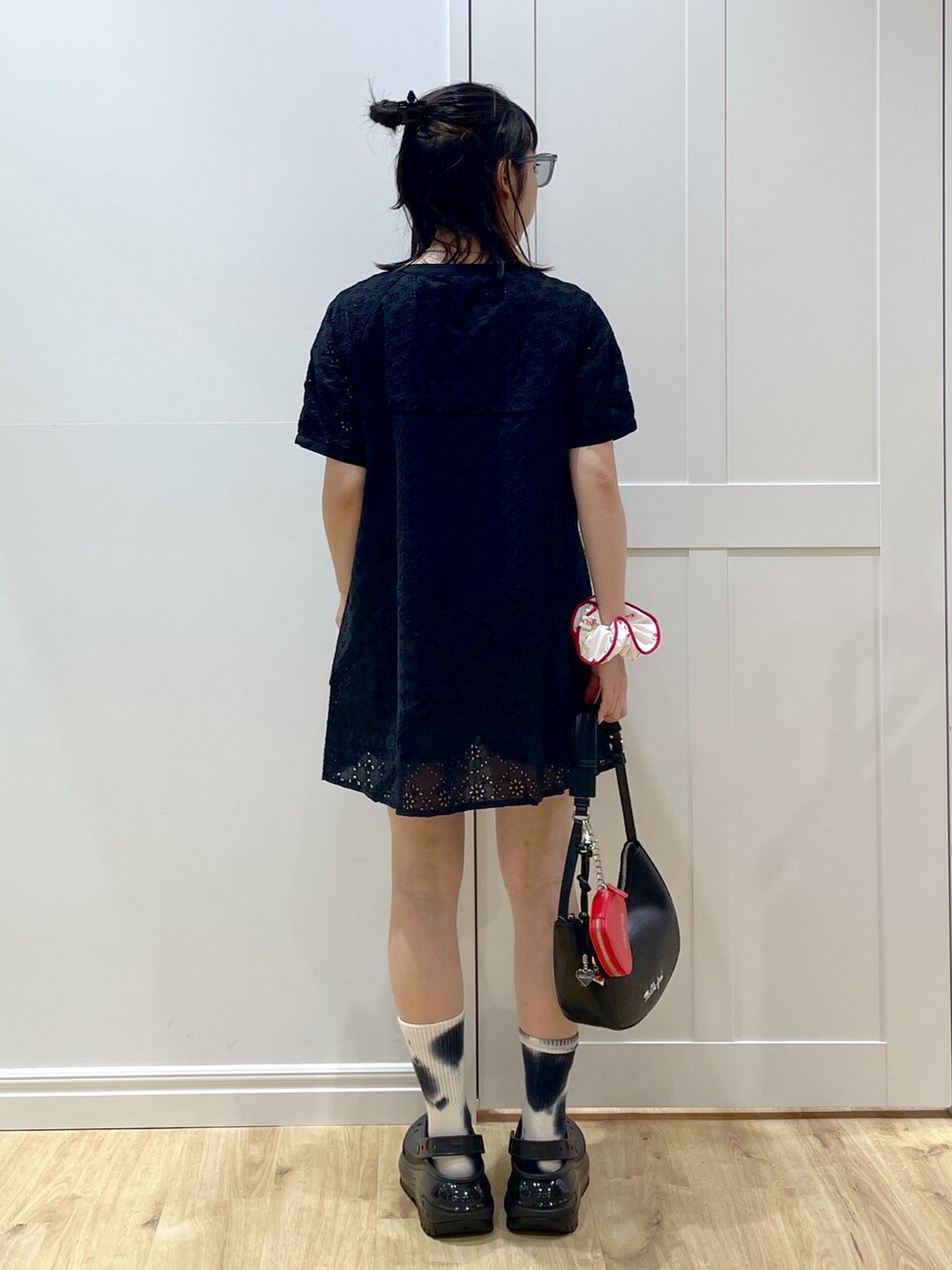 ブラック系のサンダル、ブラック系のワンピース、ブラック系のハンドバッグを着用したレディースの夏コーディネートの3枚目の写真