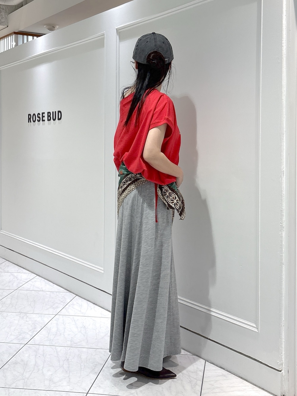 ブラウン系のパンプス、グレー系のスカート、レッド系のTシャツ/カットソーを着用したレディースの夏コーディネートの2枚目の写真