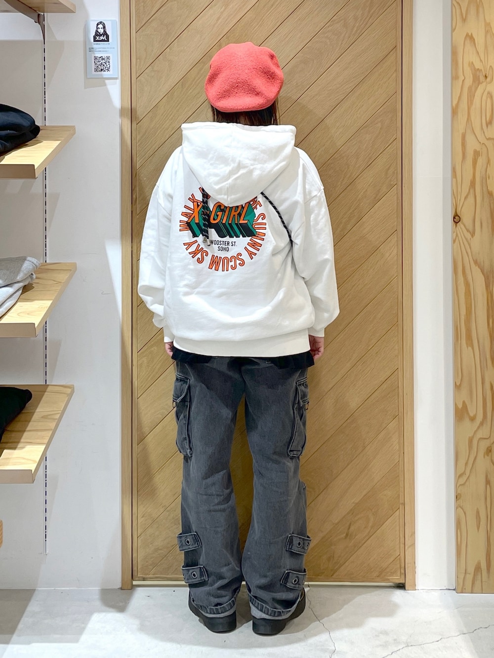 ホワイト系のパーカー、ブラック系のカーゴパンツ、ブラック系のブーツを着用したレディースの冬コーディネートの2枚目の写真