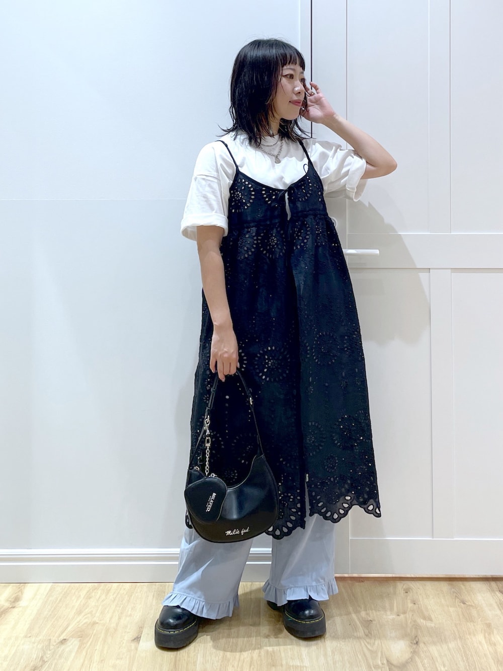 ブルー系のその他パンツ、ブラック系のブーツ、ブラック系のハンドバッグを着用したレディースの夏コーディネートの2枚目の写真