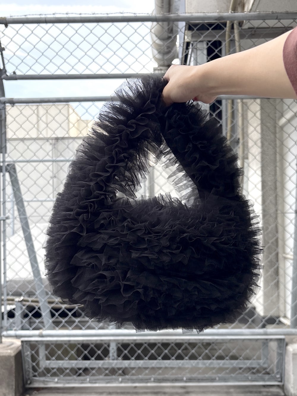 ブルー系のデニムパンツ、レッド系のスニーカー、ホワイト系のスカートを着用したレディースの春コーディネートの6枚目の写真