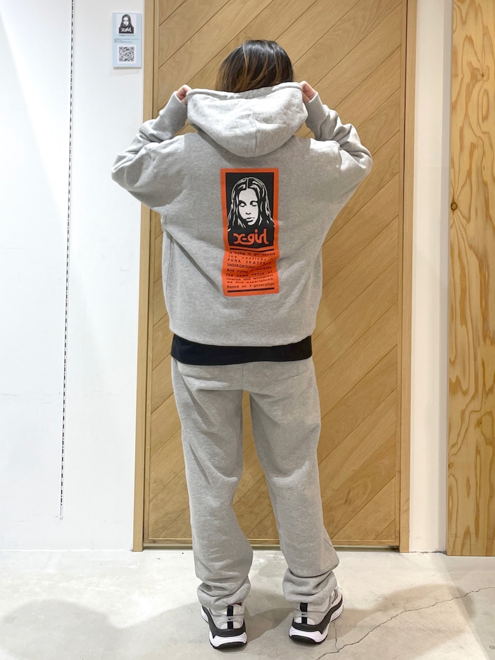 グレー系のスウェットパンツ、ホワイト系のスニーカー、グレー系のパーカーを着用したレディースの冬コーディネートの2枚目の写真