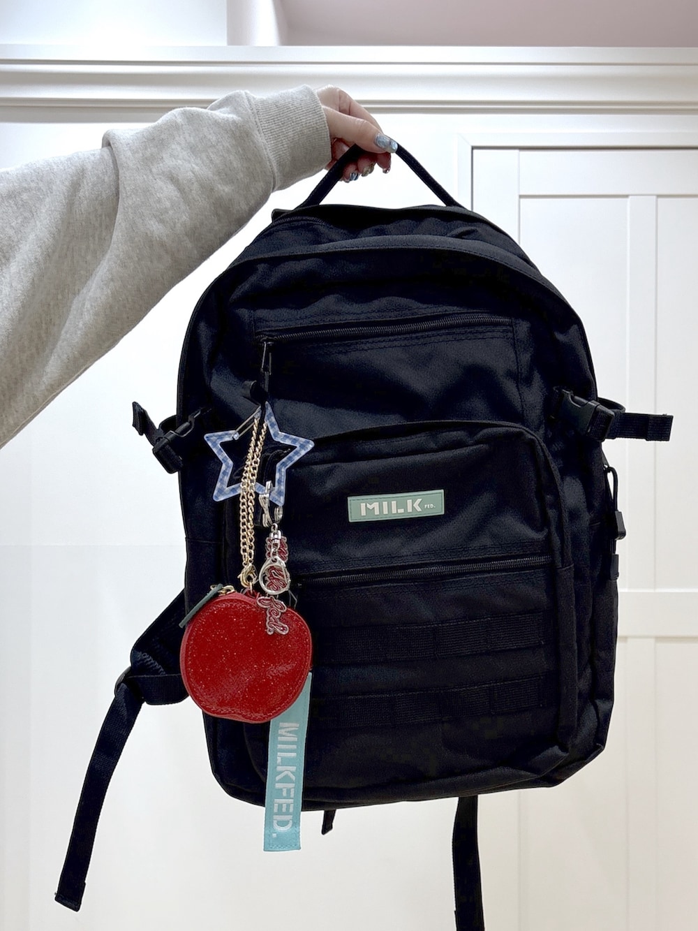 ブラック系のスカート、ベージュ系のスウェット、グリーン系のバックパック/リュックを着用したレディースの春コーディネートの7枚目の写真