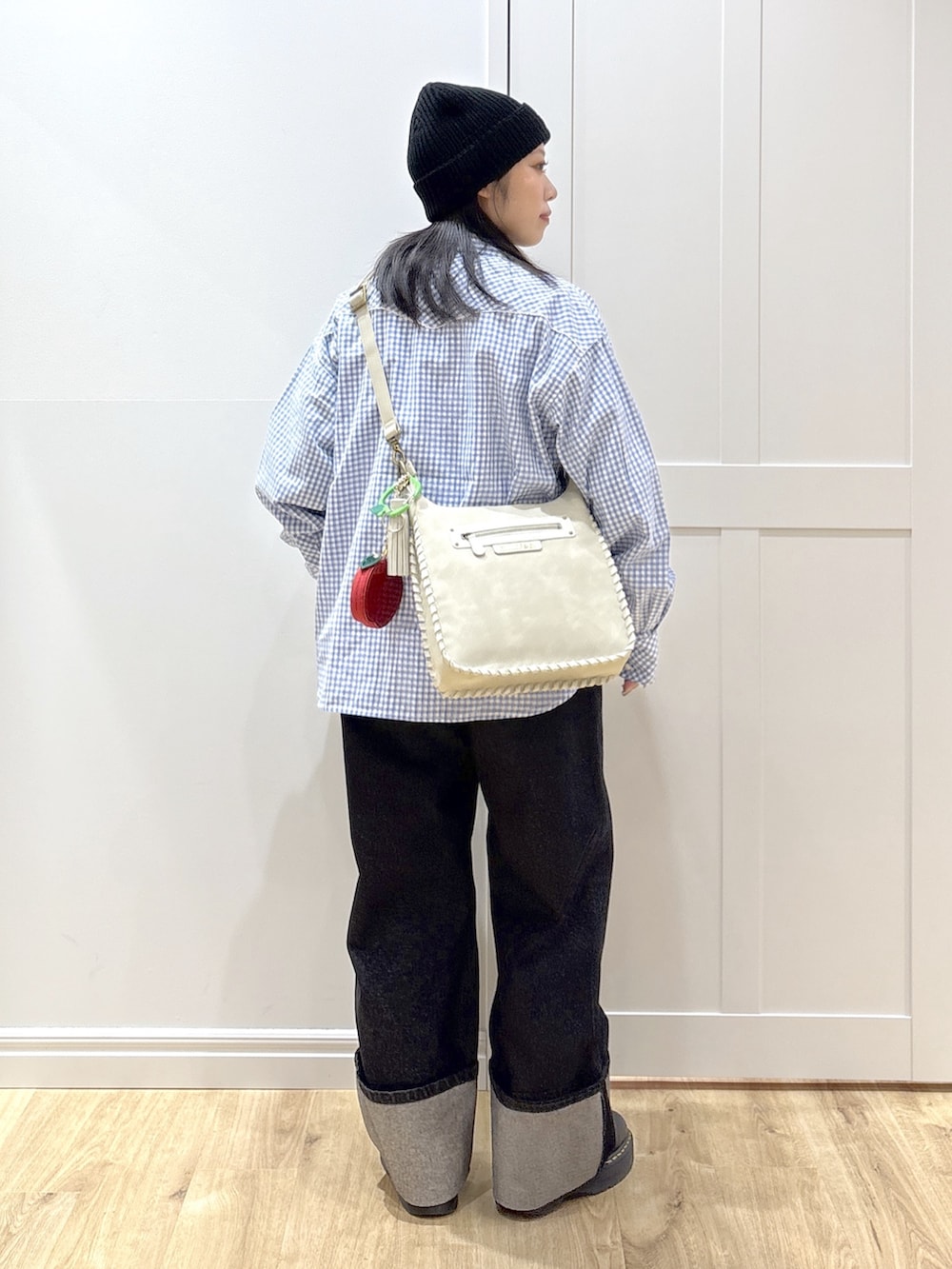 ブラック系のデニムパンツ、ホワイト系のTシャツ/カットソー、グレー系のショルダーバッグを着用したレディースの冬コーディネートの2枚目の写真