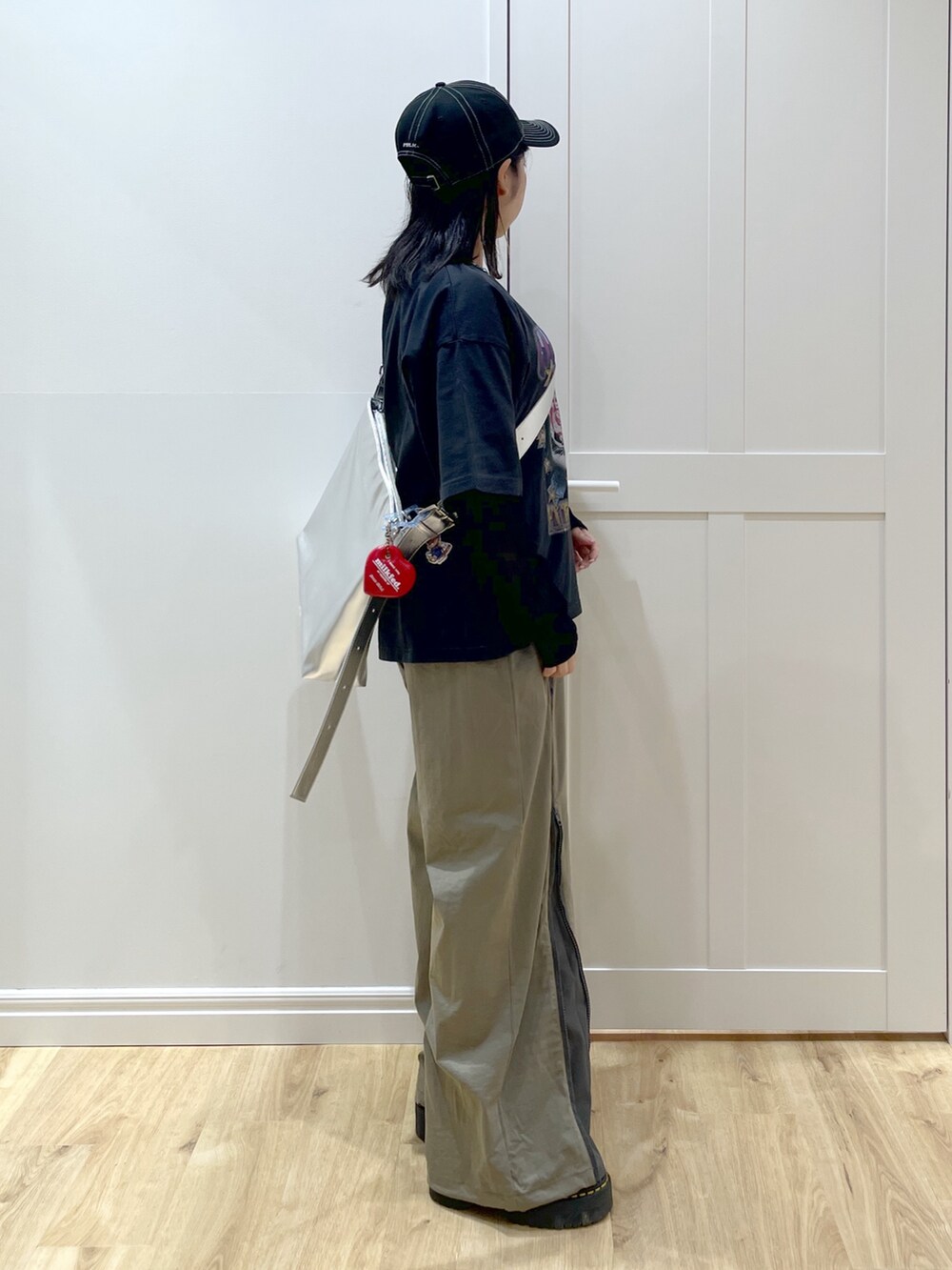 ブラック系のTシャツ/カットソー、シルバー系のショルダーバッグ、ブラック系のブーツを着用したレディースの夏コーディネートの3枚目の写真