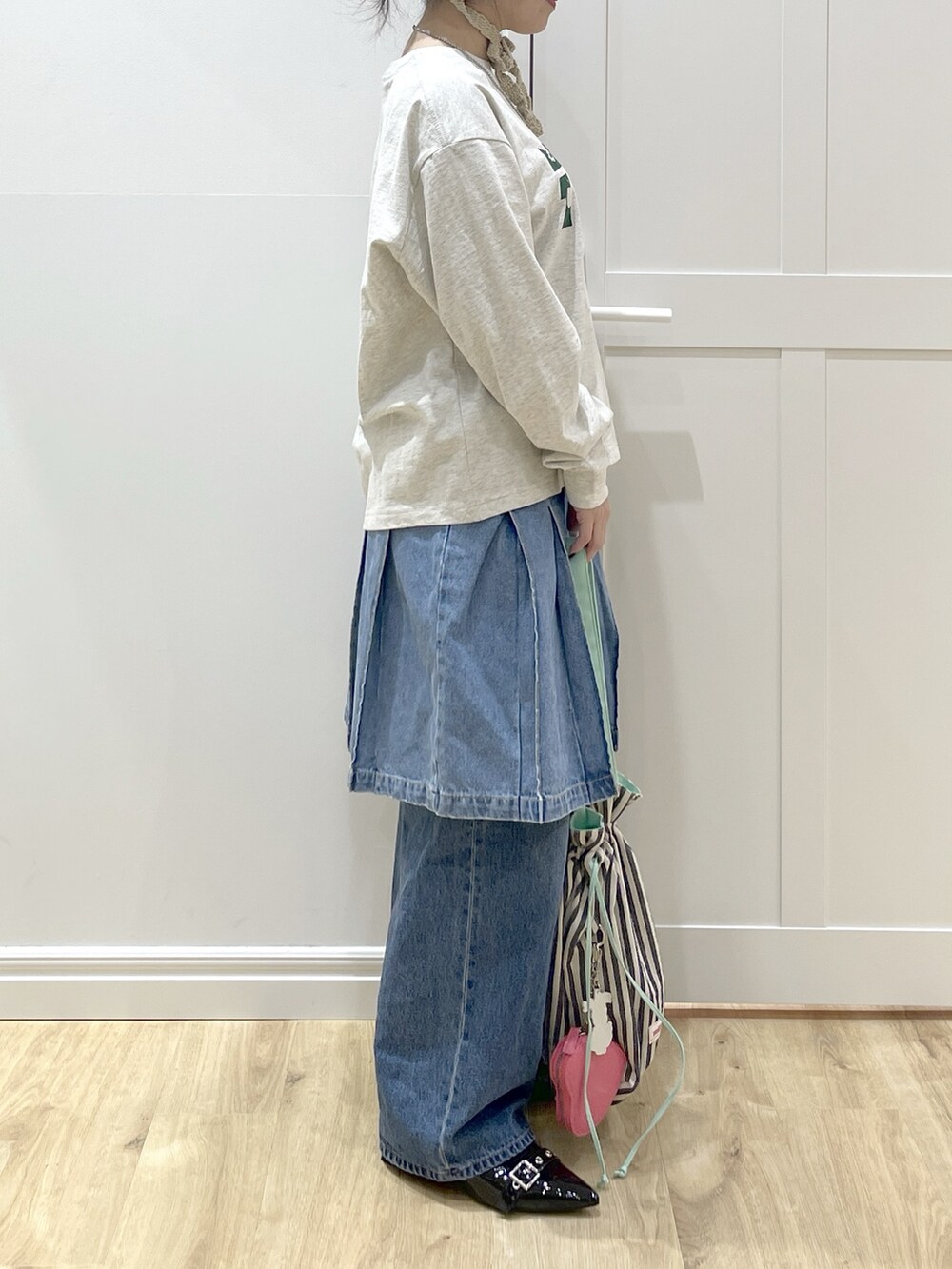 ホワイト系のダウンジャケット/コート、ベージュ系のTシャツ/カットソー、ブルー系のデニムパンツを着用したレディースの冬コーディネートの6枚目の写真