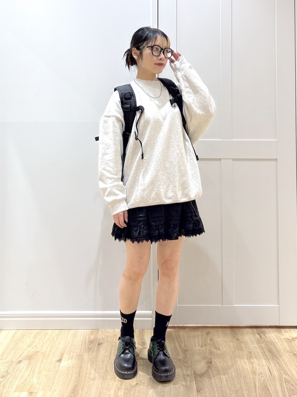 ブラック系のスカート、ベージュ系のスウェット、グリーン系のバックパック/リュックを着用したレディースの春コーディネートの3枚目の写真