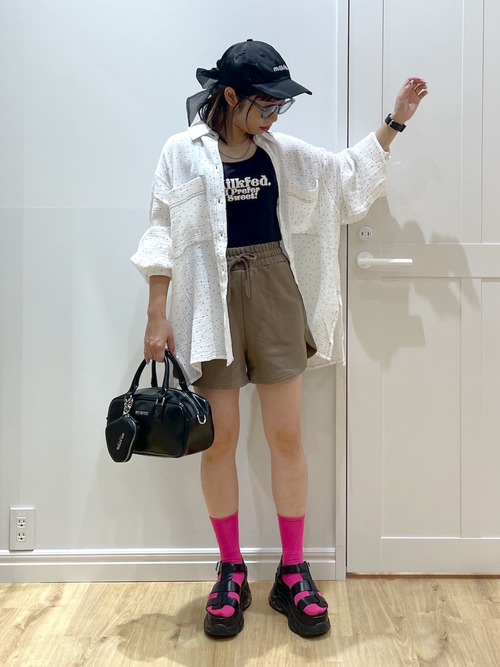 ブラック系のショルダーバッグ、ブラック系のサンダル、ブラック系のタンクトップを着用したレディースの夏コーディネートの5枚目の写真