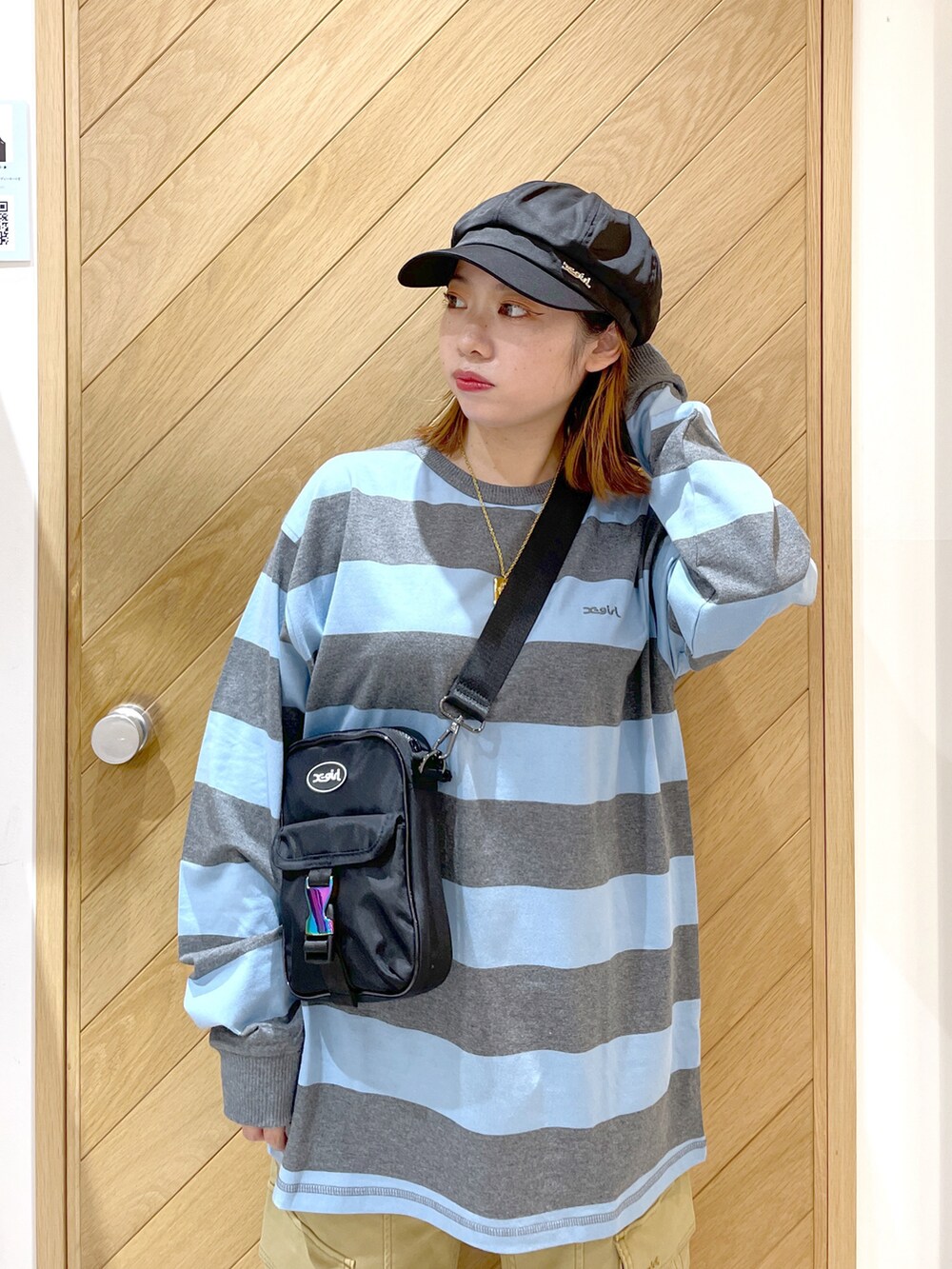 ベージュ系のカーゴパンツ、ブラック系のスニーカー、ブルー系のTシャツ/カットソーを着用したレディースの秋コーディネートの2枚目の写真