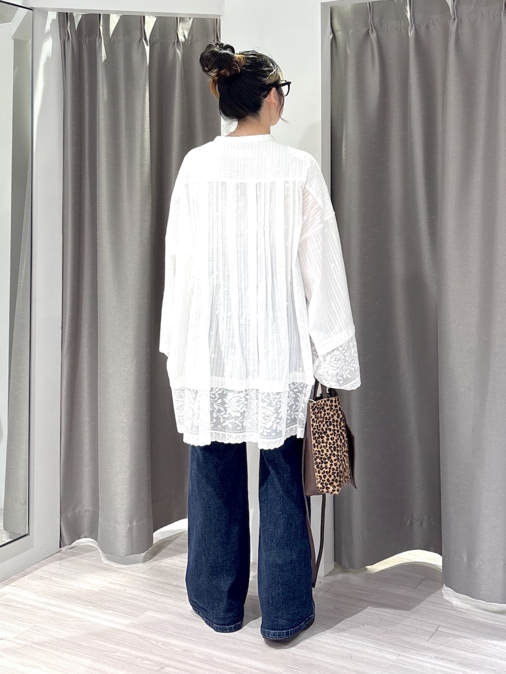 ホワイト系のシャツ/ブラウス、ブルー系のデニムパンツ、ブラック系のブーツを着用したレディースの秋コーディネートの3枚目の写真