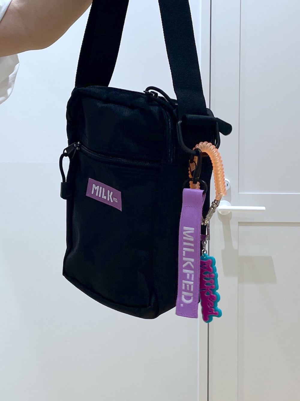 パープル系のショルダーバッグ、ブラック系のブーツ、ブラック系のその他パンツを着用したレディースの夏コーディネートの4枚目の写真