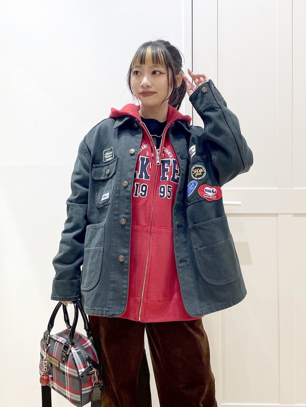 ブラック系のTシャツ/カットソー、レッド系のパーカー、ブラック系のブルゾンを着用したレディースの秋コーディネートの4枚目の写真