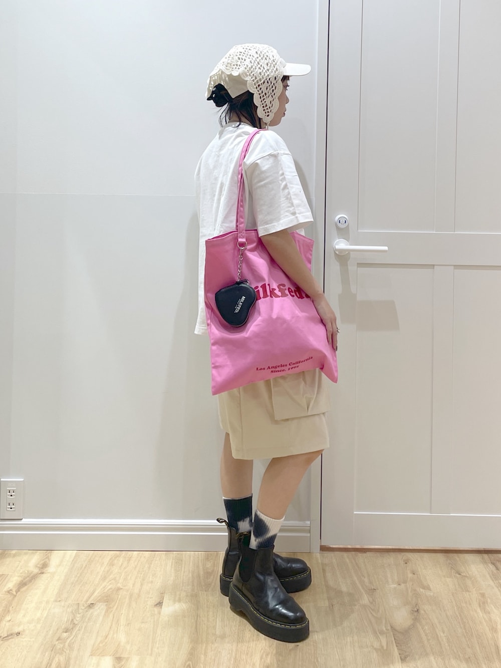 ブラック系のブーツ、ホワイト系のトートバッグ、ホワイト系のTシャツ/カットソーを着用したレディースの春コーディネートの2枚目の写真