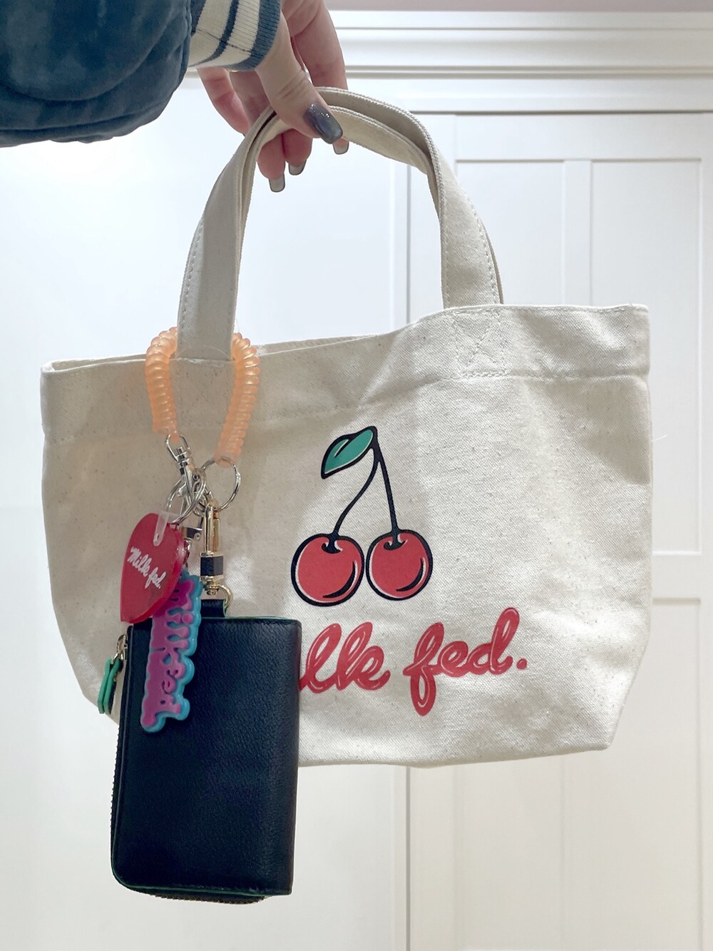 グレー系のパーカー、ブラック系のスカート、グリーン系のスタジャンを着用したレディースの冬コーディネートの7枚目の写真