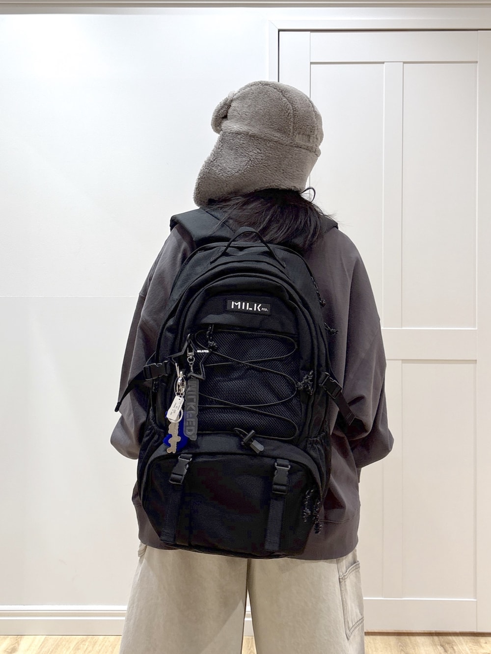 ホワイト系のデニムパンツ、グレー系のスウェット、ブラック系のバックパック/リュックを着用したレディースの冬コーディネートの5枚目の写真