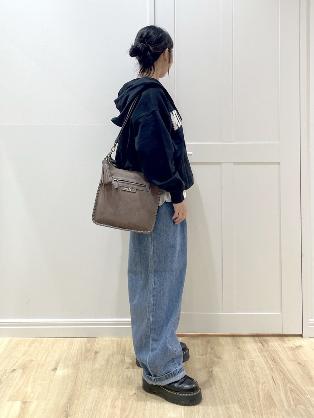 ブラック系のブーツ、ホワイト系のTシャツ/カットソー、ブラック系のパーカーを着用したレディースの秋コーディネートの3枚目の写真