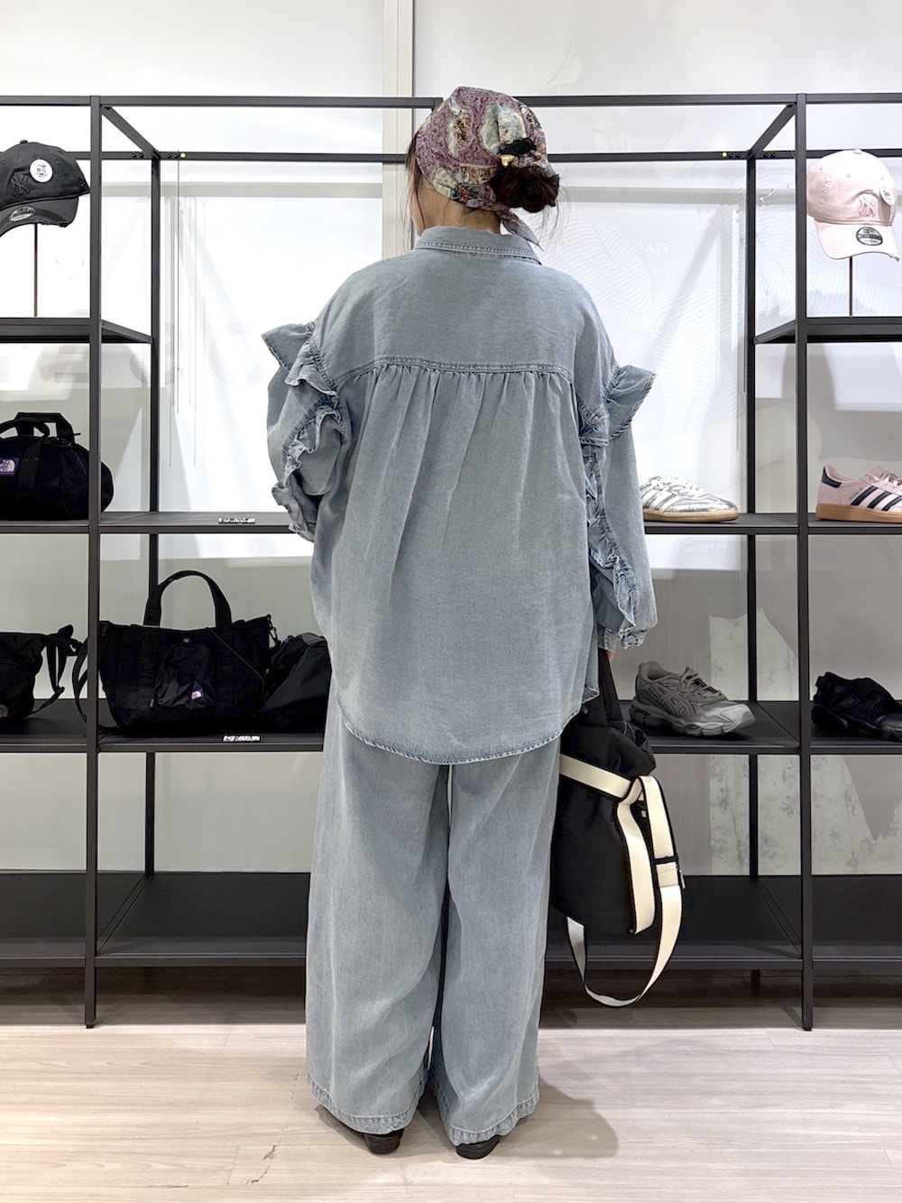 ブラック系のその他シューズ、ブラック系のトートバッグ、ブルー系のデニムパンツを着用したレディースの春コーディネートの4枚目の写真