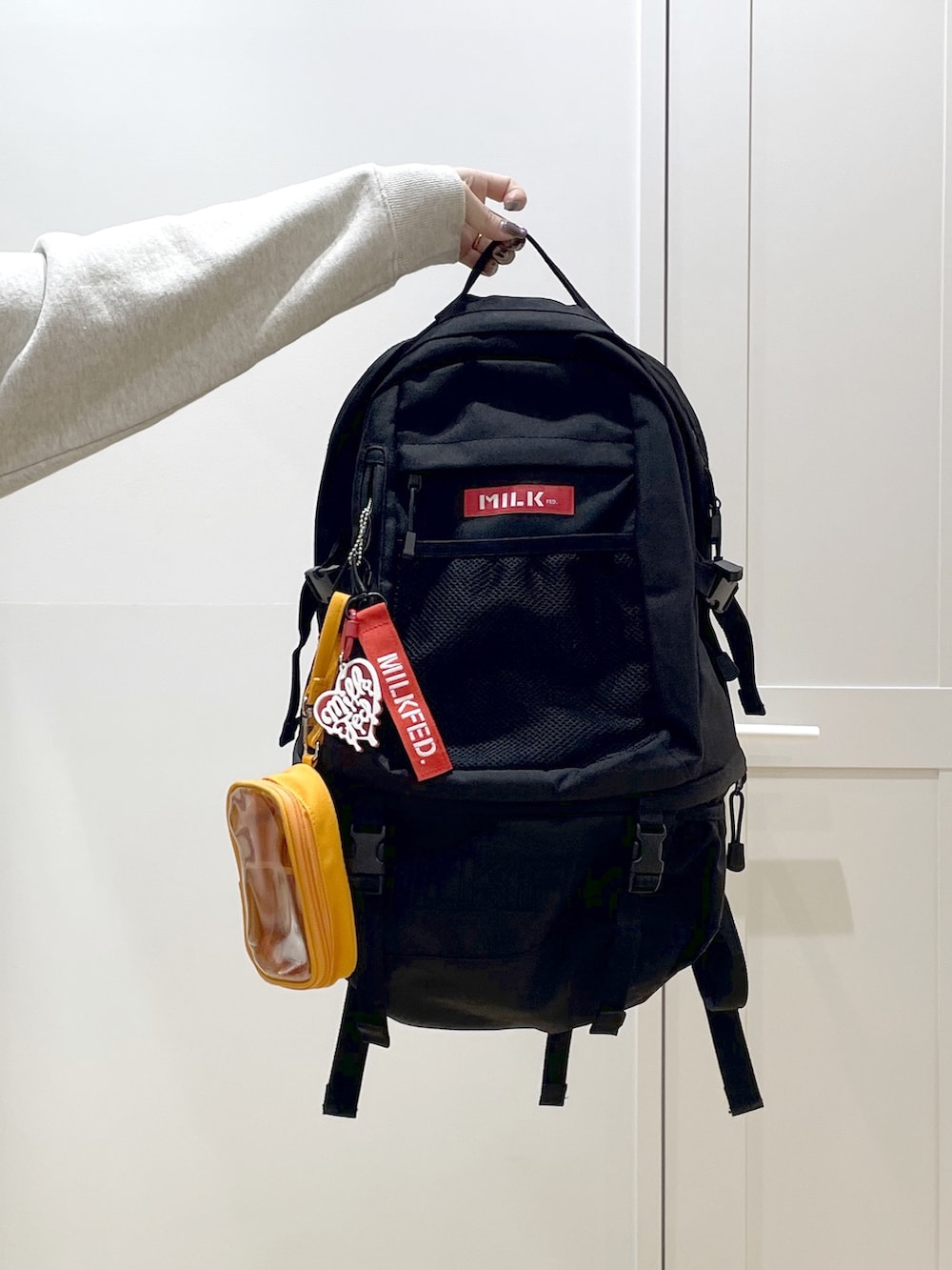 ブラック系のデニムパンツ、ベージュ系のパーカー、レッド系のバックパック/リュックを着用したレディースの冬コーディネートの9枚目の写真