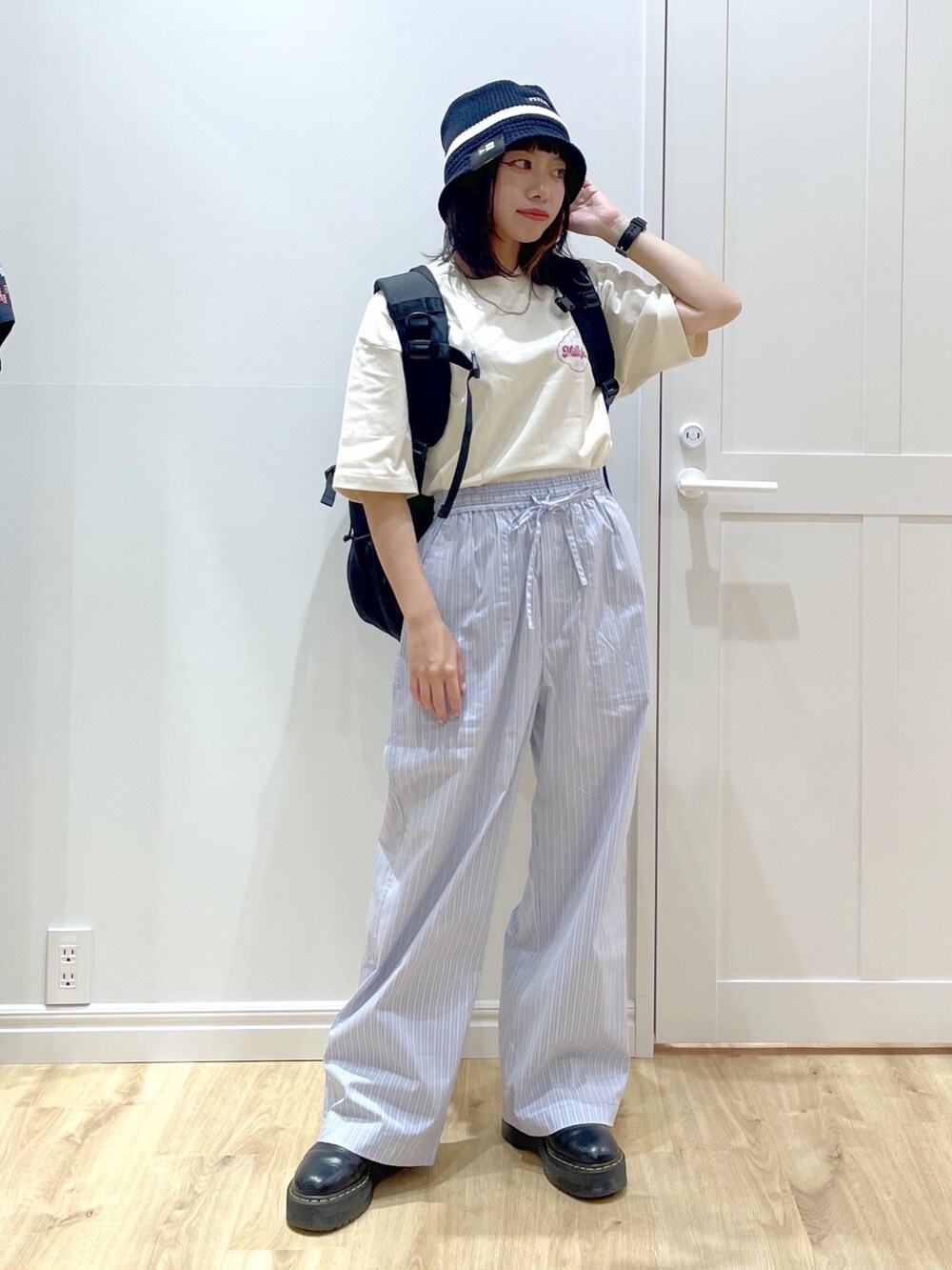 ホワイト系のTシャツ/カットソー、ブルー系のその他パンツ、ブラック系のブーツを着用したレディースの夏コーディネートの2枚目の写真