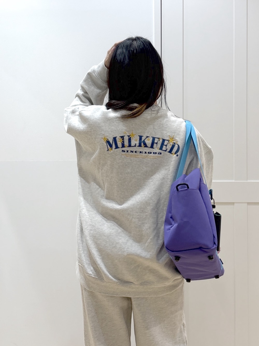 ベージュ系のスウェット、ベージュ系のスウェットパンツ、パープル系のショルダーバッグを着用したレディースの冬コーディネートの5枚目の写真