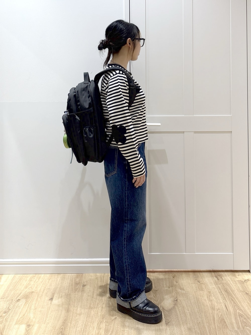 ブルー系のデニムパンツ、ブラック系のブーツ、ブラック系のカーディガン/ボレロを着用したレディースの春コーディネートの2枚目の写真