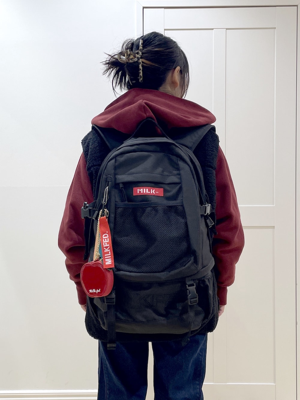 ベージュ系のブーツ、ブルー系のデニムパンツ、ブラック系のベストを着用したレディースの秋コーディネートの6枚目の写真