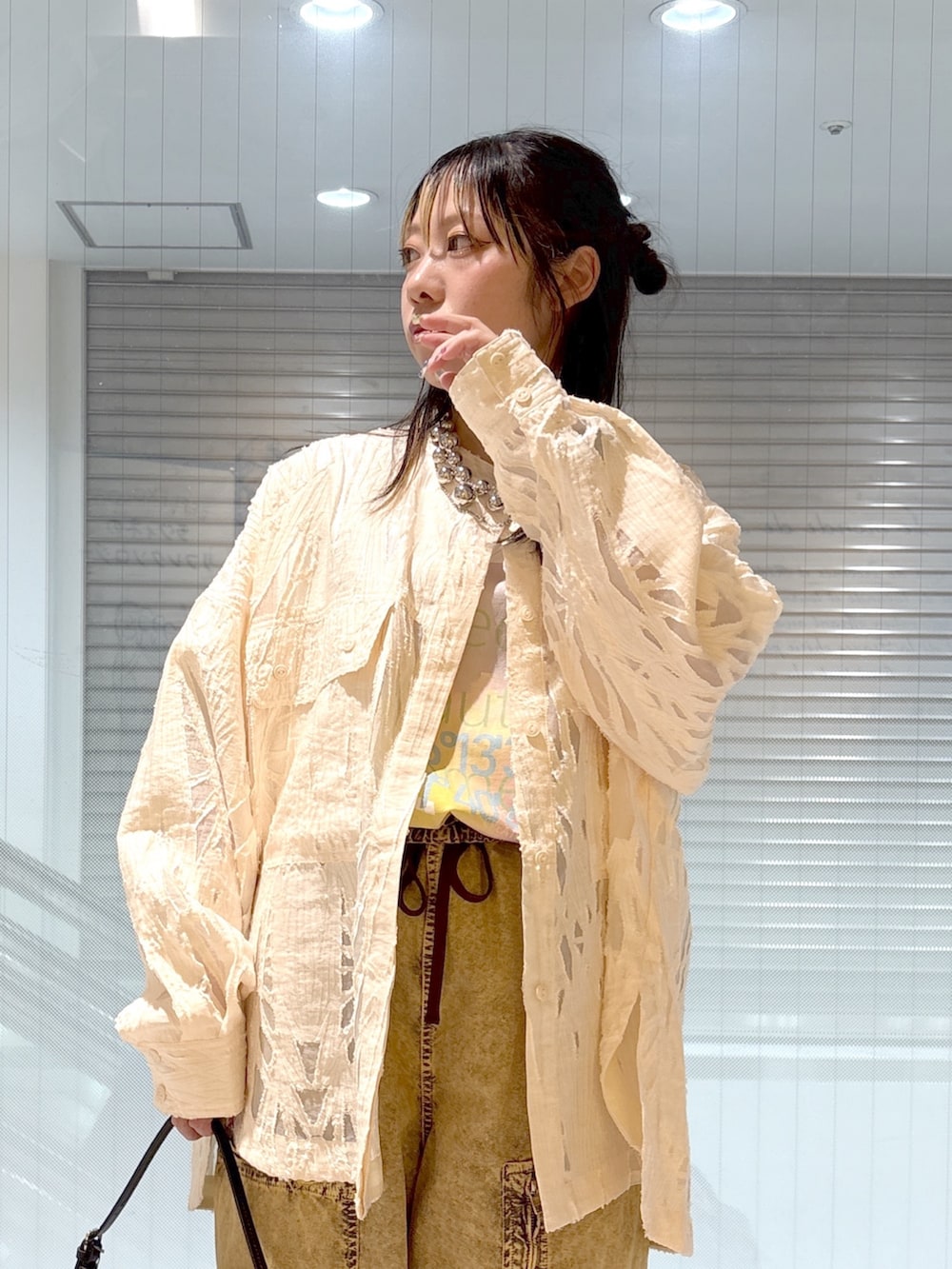 ブラック系のブーツ、ホワイト系のTシャツ/カットソー、ブラック系のショルダーバッグを着用したレディースの春コーディネートの5枚目の写真