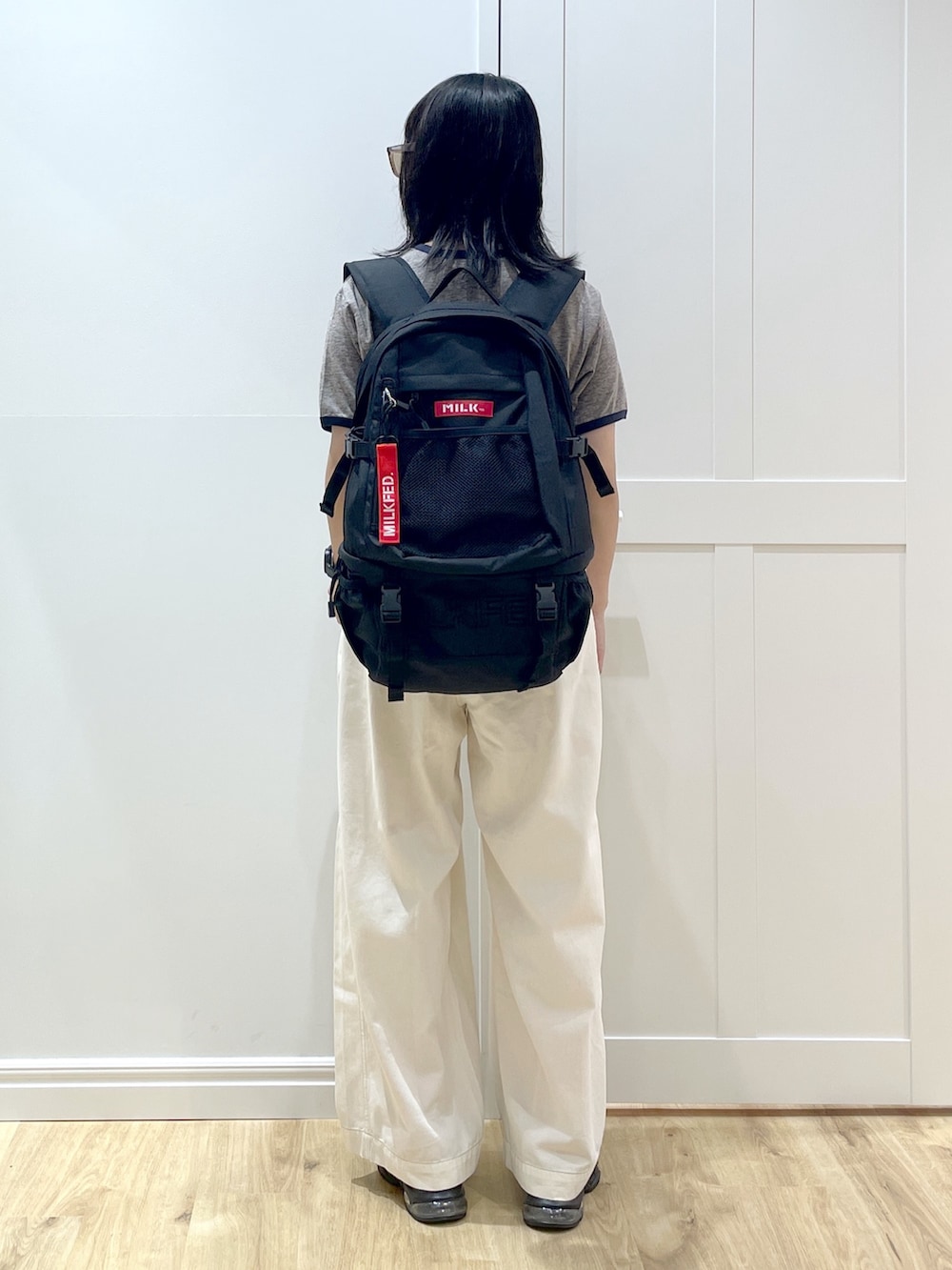 ホワイト系のその他パンツ、グレー系のTシャツ/カットソー、レッド系のバックパック/リュックを着用したレディースの夏コーディネートの2枚目の写真