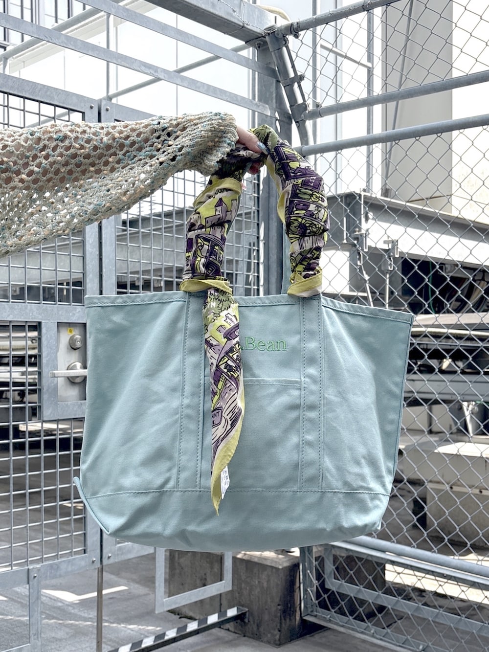 ブラック系のブーツ、ブルー系のニット/セーター、ホワイト系のスカートを着用したレディースの春コーディネートの7枚目の写真