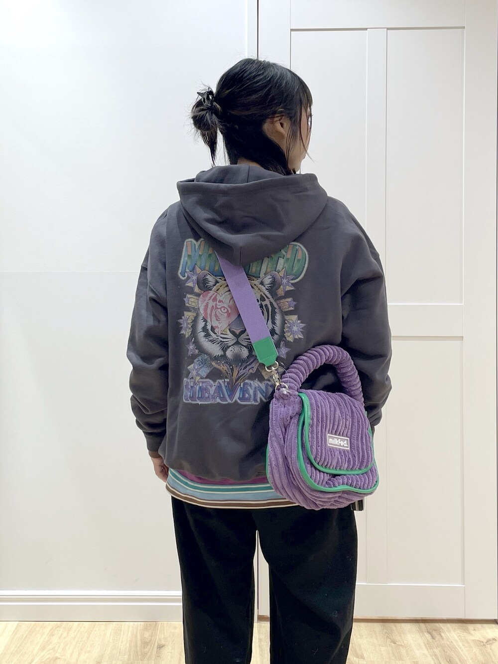 パープル系のショルダーバッグ、グレー系のパーカー、パープル系のTシャツ/カットソーを着用したレディースの秋コーディネートの4枚目の写真