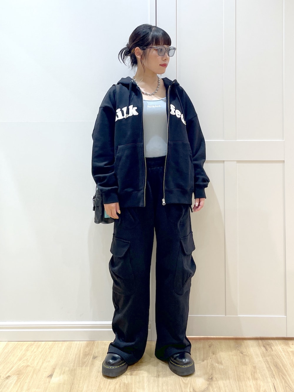 ブラック系のブーツ、ブラック系のスウェットパンツ、ブラック系のパーカーを着用したレディースの夏コーディネートの2枚目の写真