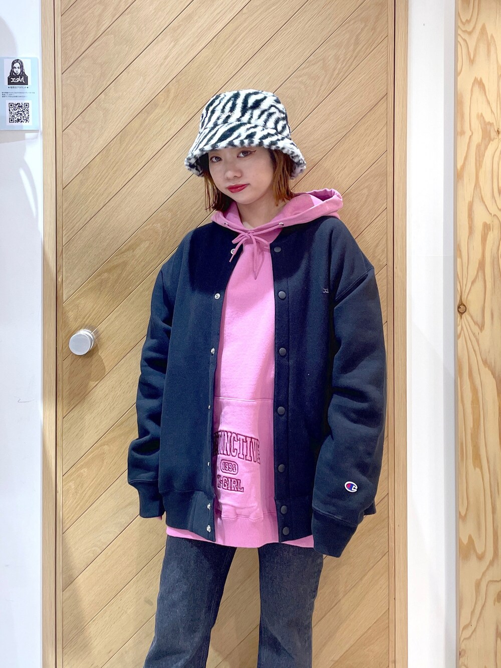 ブラック系のデニムパンツ、ブラック系のブーツ、ピンク系のパーカーを着用したレディースの秋コーディネートの3枚目の写真