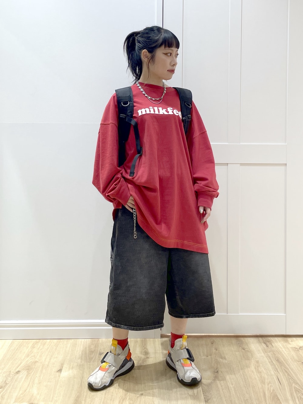 レッド系のバックパック/リュック、ブラック系のデニムパンツ、レッド系のTシャツ/カットソーを着用したレディースの秋コーディネートの2枚目の写真