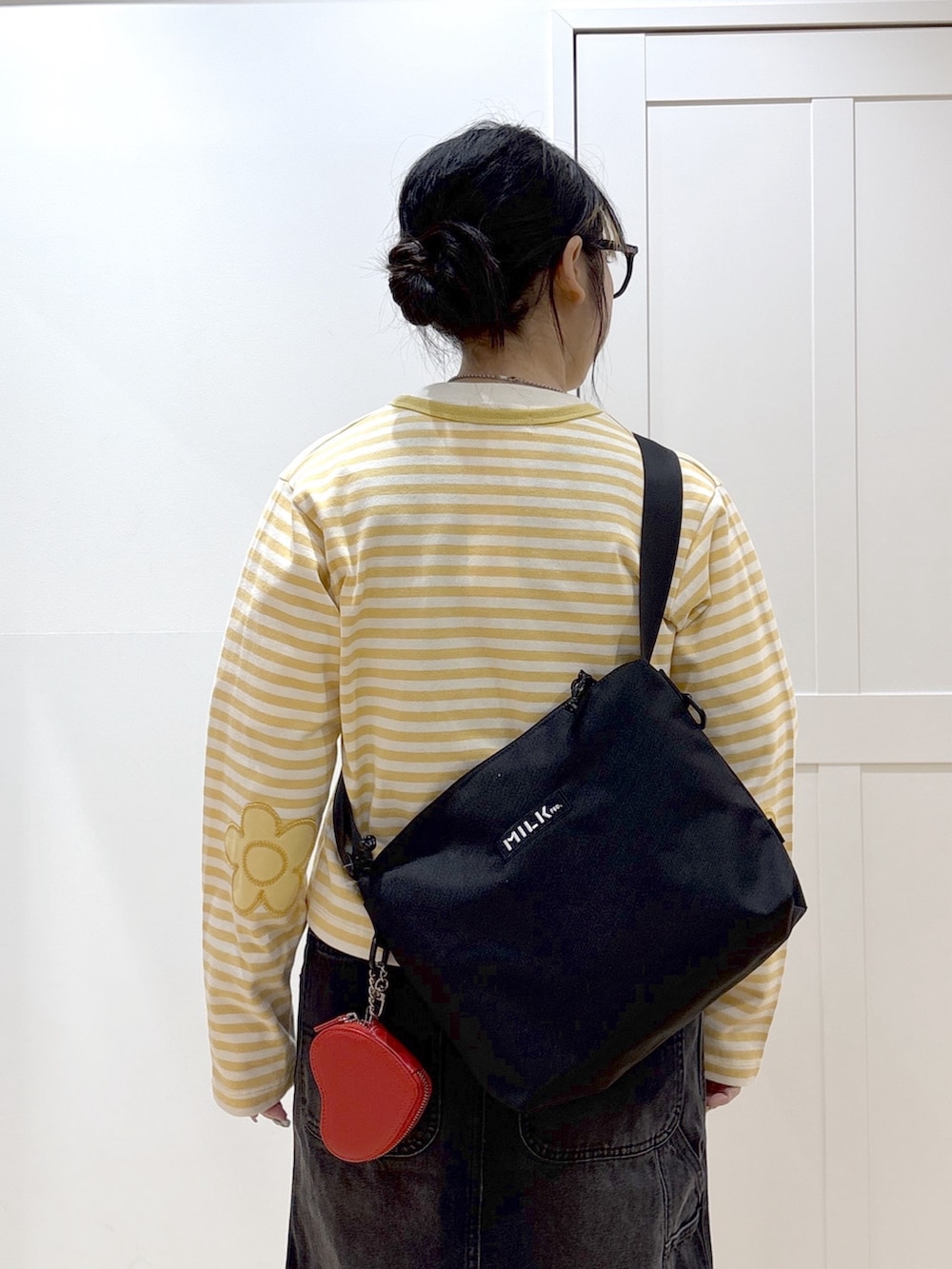 ブラック系のサロペット/オーバーオール、イエロー系のカーディガン/ボレロ、ホワイト系のTシャツ/カットソーを着用したレディースの春コーディネートの5枚目の写真