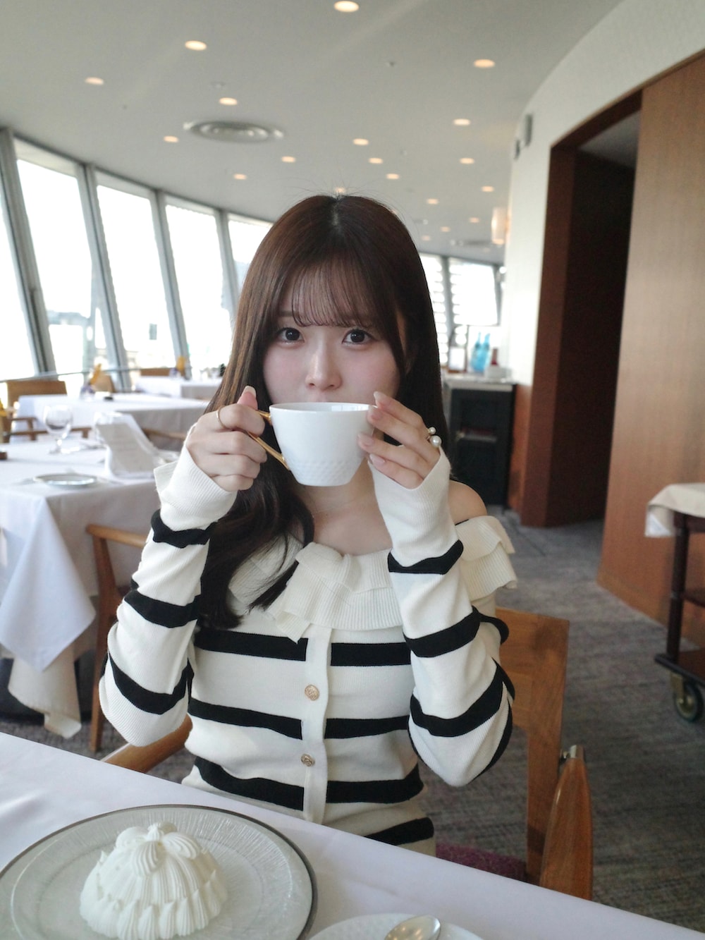 ホワイト系のトップス、ブラック系のスカート、ホワイト系のその他アウターを着用したレディースの冬コーディネートの2枚目の写真