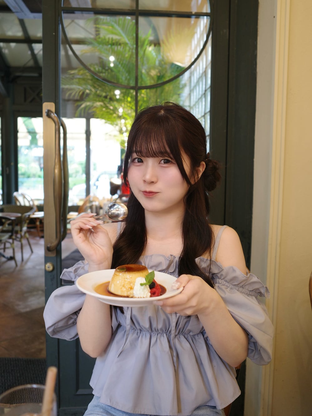 ブルー系のデニムパンツ、ホワイト系のサンダル、ホワイト系のバッグを着用したレディースの春コーディネートの2枚目の写真