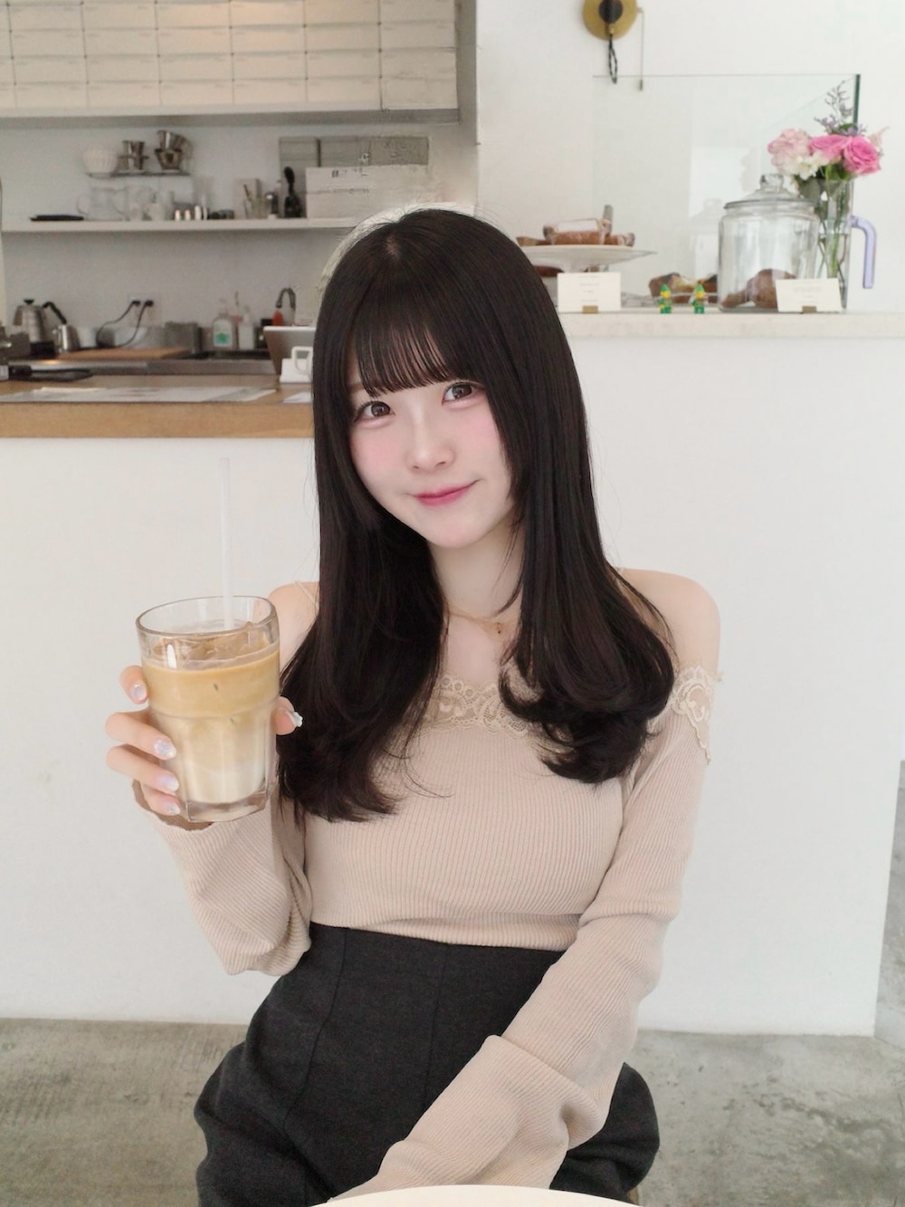 ベージュ系のトップス、グレー系のパンツ、ピンク系のバッグを着用したレディースの夏コーディネートの2枚目の写真
