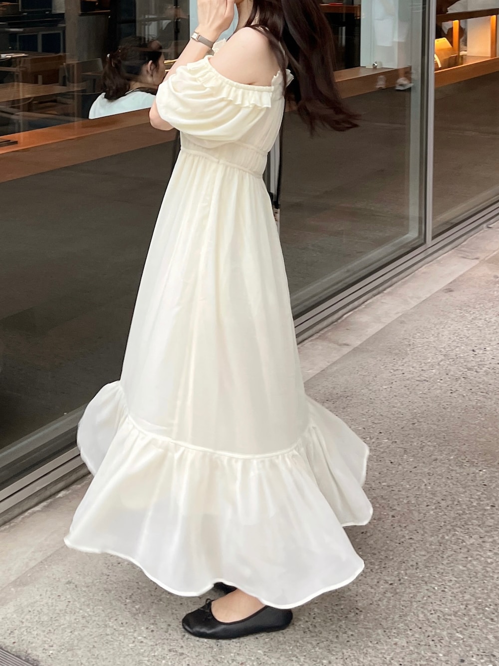 ブラック系のバッグ、ベージュ系のワンピースを着用したレディースの夏コーディネートの3枚目の写真