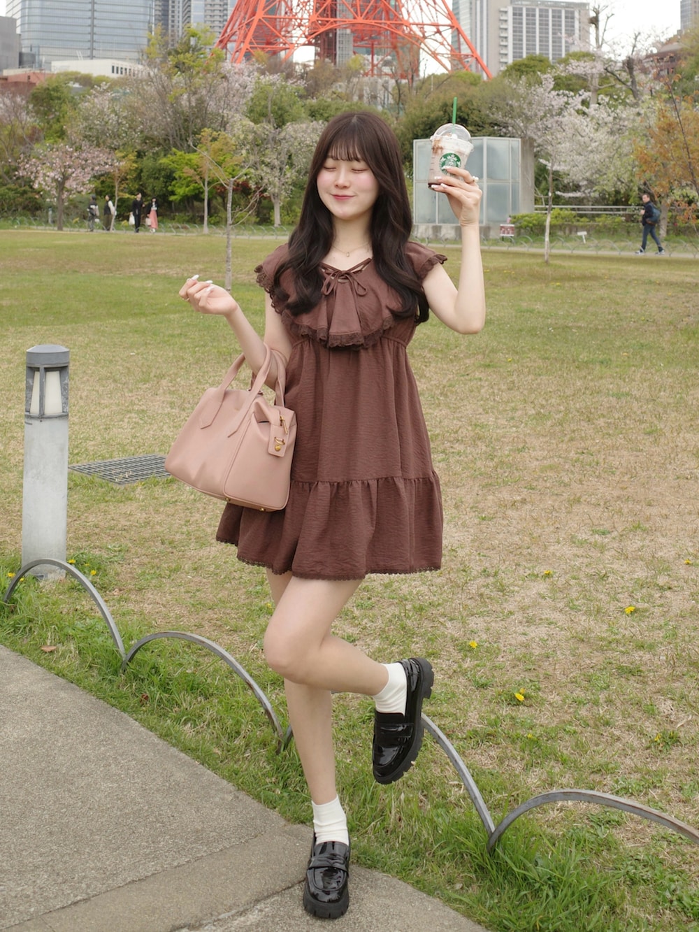 ピンク系のバッグ、ブラック系のローファー、ブラウン系のワンピース/ドレスを着用したレディースの春コーディネートの2枚目の写真