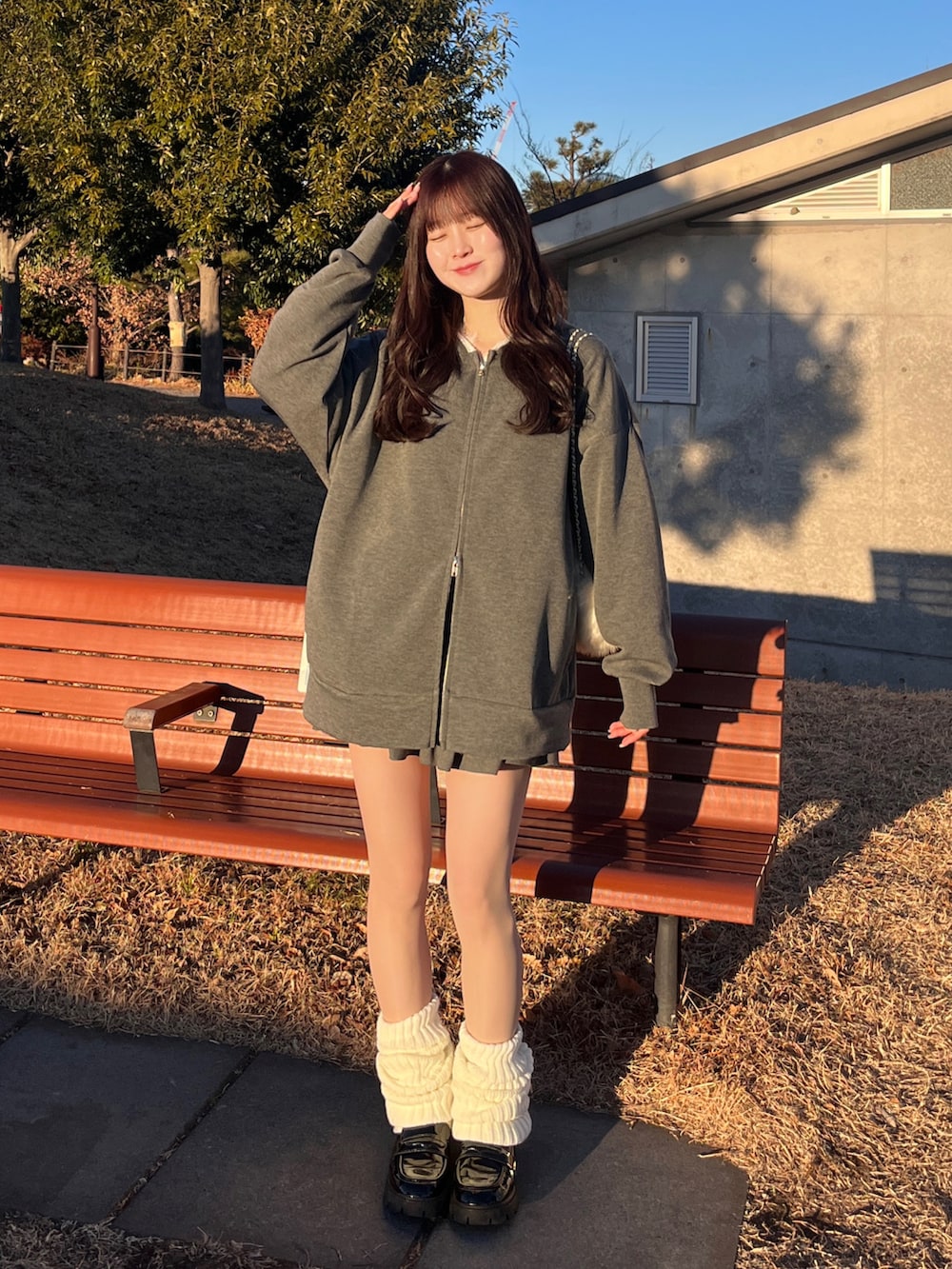 グレー系のセットアップ、ホワイト系のレッグウォーマーを着用したレディースの冬コーディネートの2枚目の写真