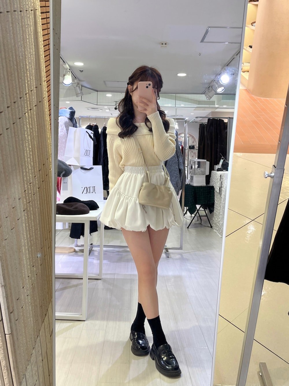 ホワイト系のニット/セーター、ホワイト系のスカート、ベージュ系のショルダーバッグを着用したレディースの秋コーディネートの3枚目の写真