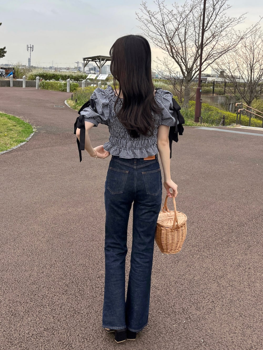 ブルー系のデニムパンツ、ブラック系のシャツ/ブラウス、ブラック系のサンダルを着用したレディースの春コーディネートの2枚目の写真